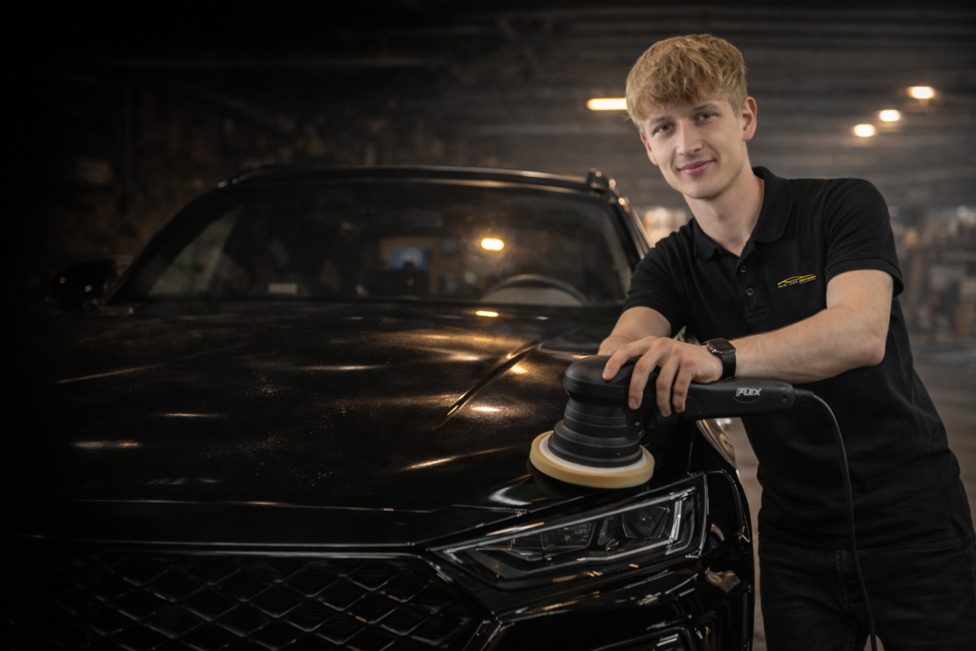 Philipp Kontny von PK's Car Refresh bei der Arbeit mit einer Poliermaschine an einem schwarzen Auto.