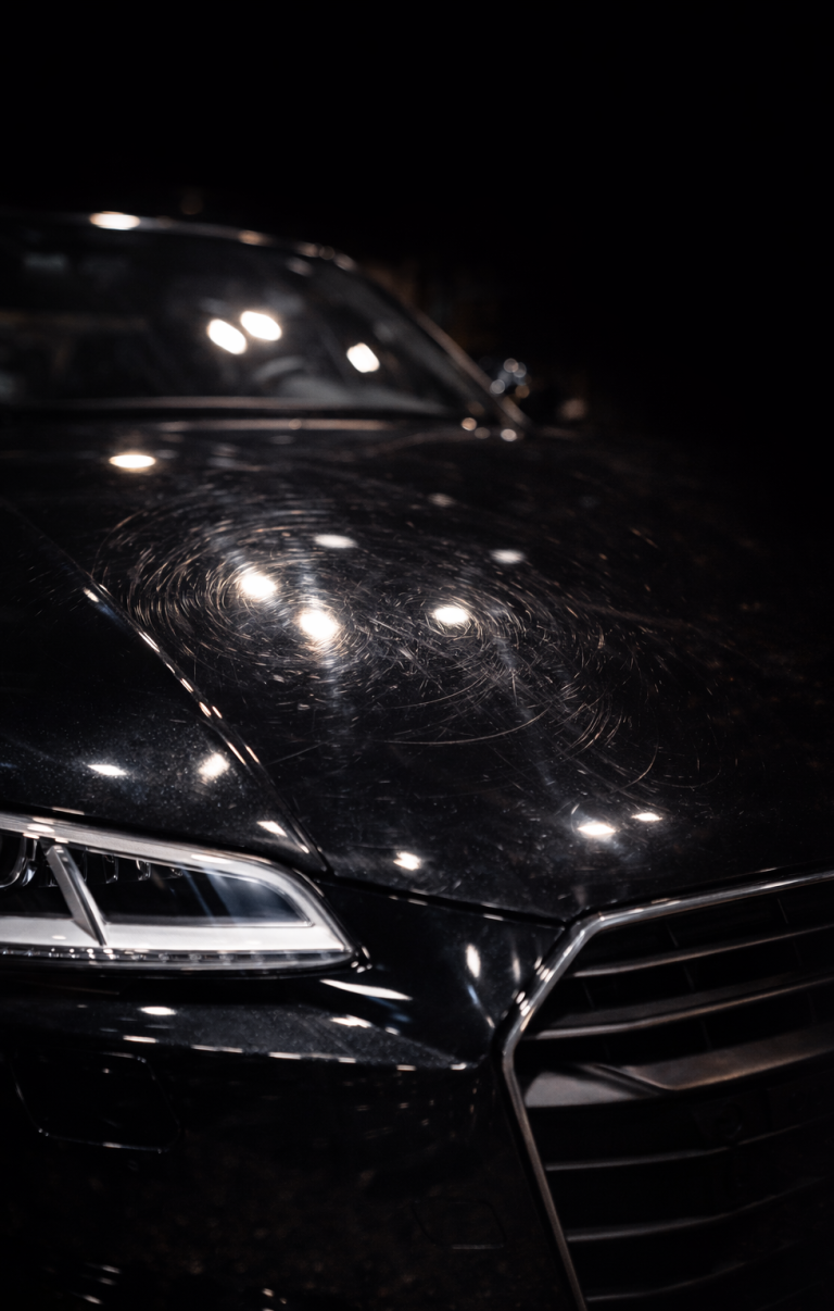 Typische Lackdefekte: Hologramme & Waschkratzer Nahaufnahme eines schwarzen Autolacks mit starken Waschkratzern, Hologrammen und matten Stellen vor der Aufbereitung.